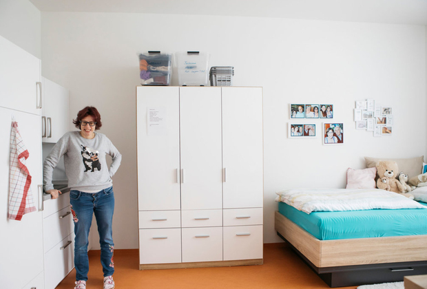 Bild: Fabienne P. in ihrer Wohnung mit kleiner Küche. 